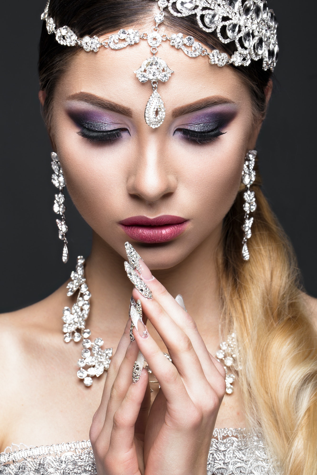 Woman in makeup and hairstyle with long nails with design